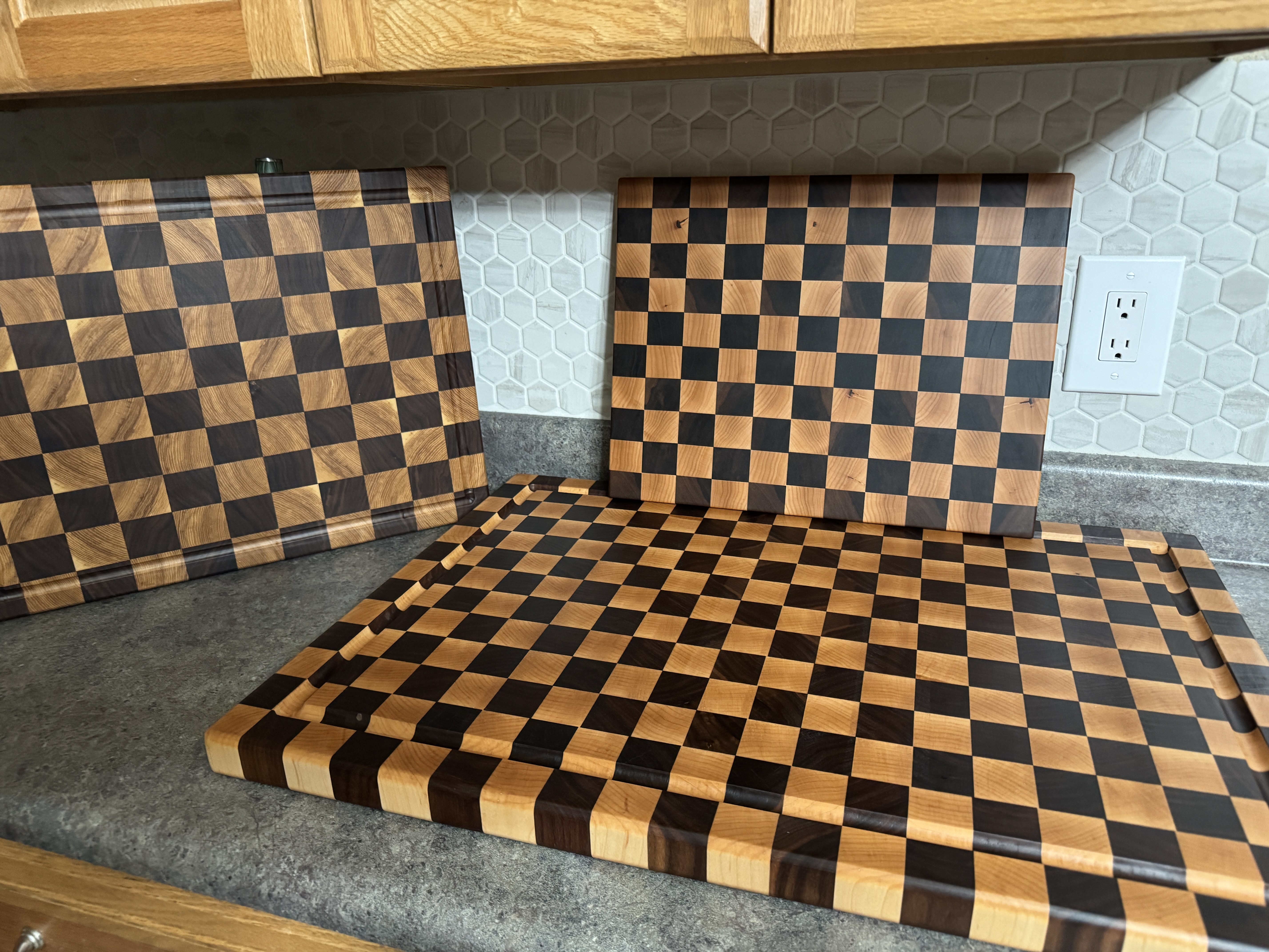 Three handcrafted checkerboard cutting boards in different sizes